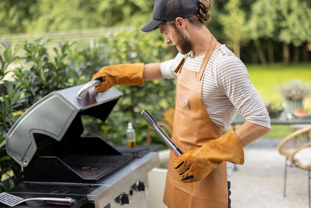 Mann grillt im Sommer