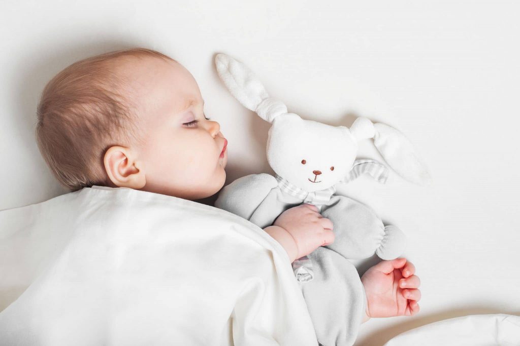 baby schläft mit teddy stoffhasen